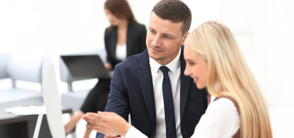 Manager discussing text message marketing and database maintenance with a colleague at the workplace