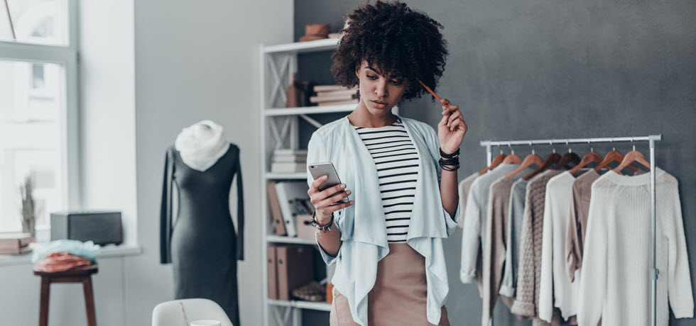 Young women in a fashion studio reading a text message