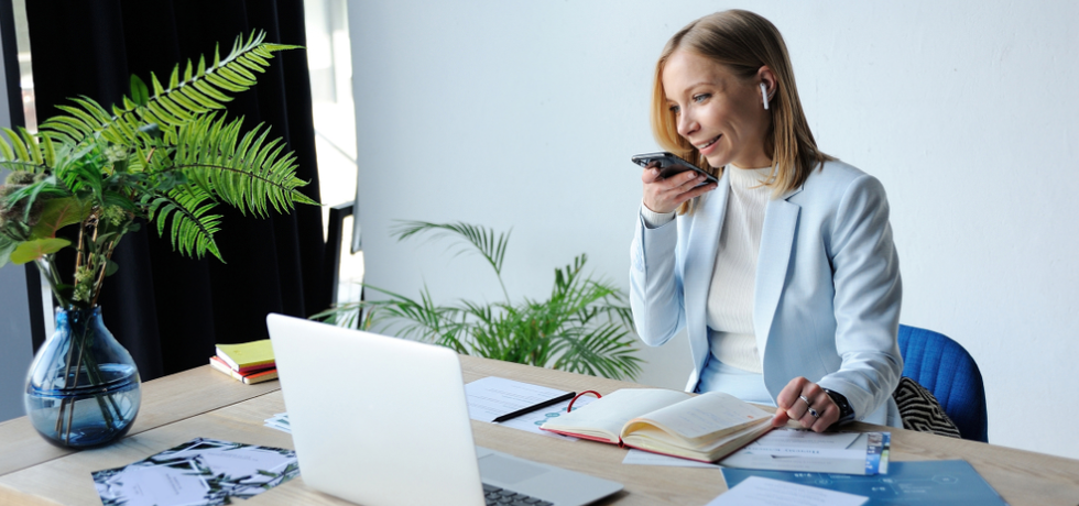 A woman using audio text messaging at office